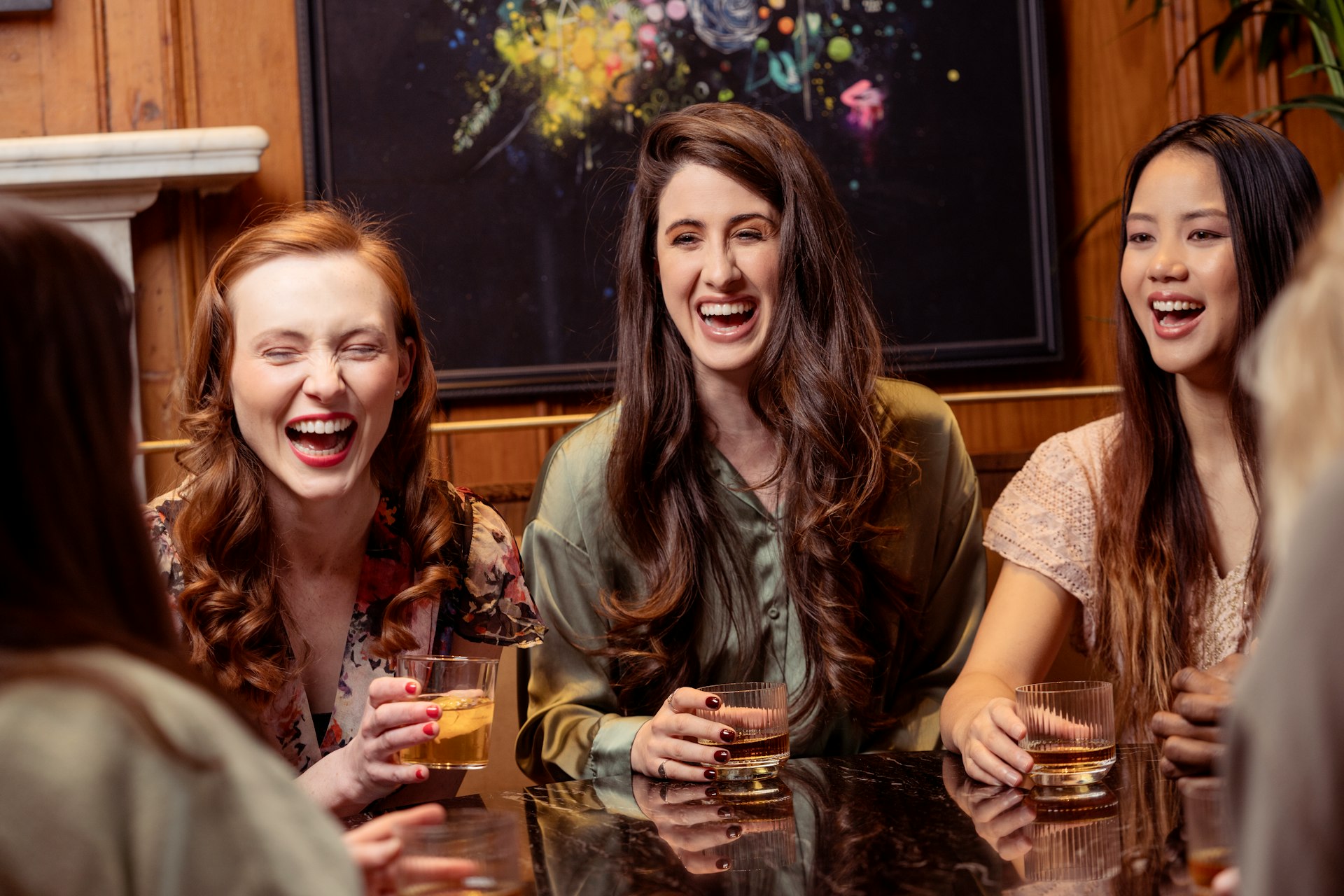 a group of women sitting around a table with drinks